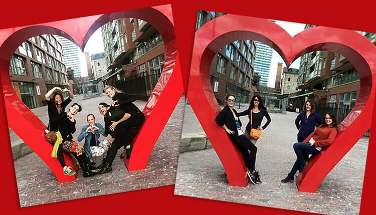 Besties pose around heart-statue outside of PoleCon.