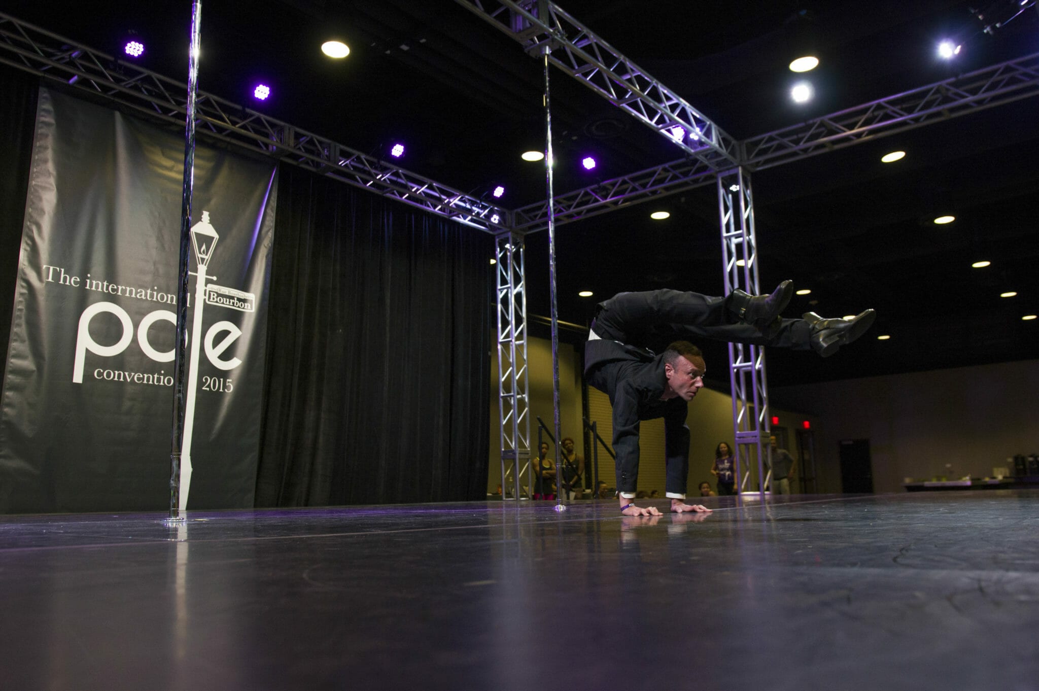 Contortionist executes a hand-stand backbend on stage.