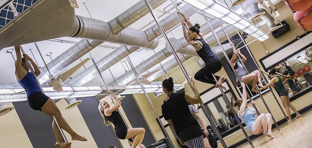 Students practice climbing in a pole class.