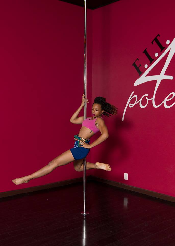 Pole dancer poses on a pole at the Fit 4 Polers studio.