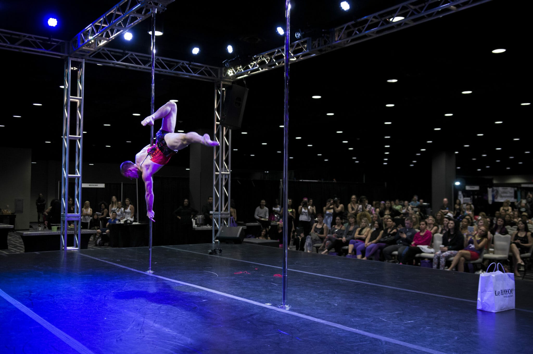 Pole dancer performs on stage at PoleCon.