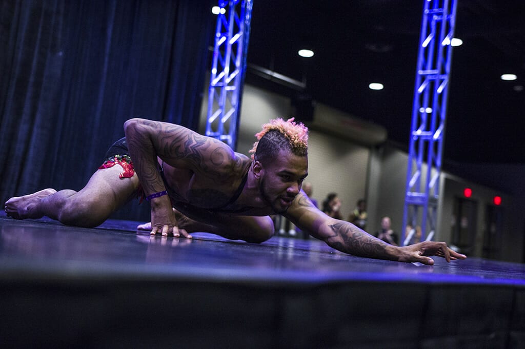 Performer with a pink mohawk slinks across the stage.