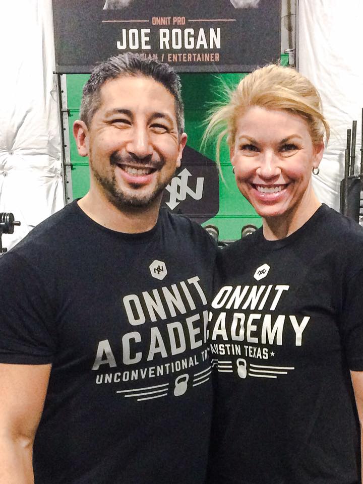 Couple smiles for the camera while wearing matching Onnit Academy t-shirts.