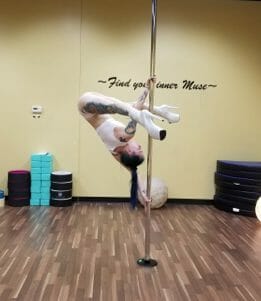 Pole dancer demonstrating Ayesha in split grip