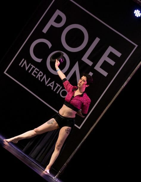 Pole Dancer strikes a dramatic pose on stage