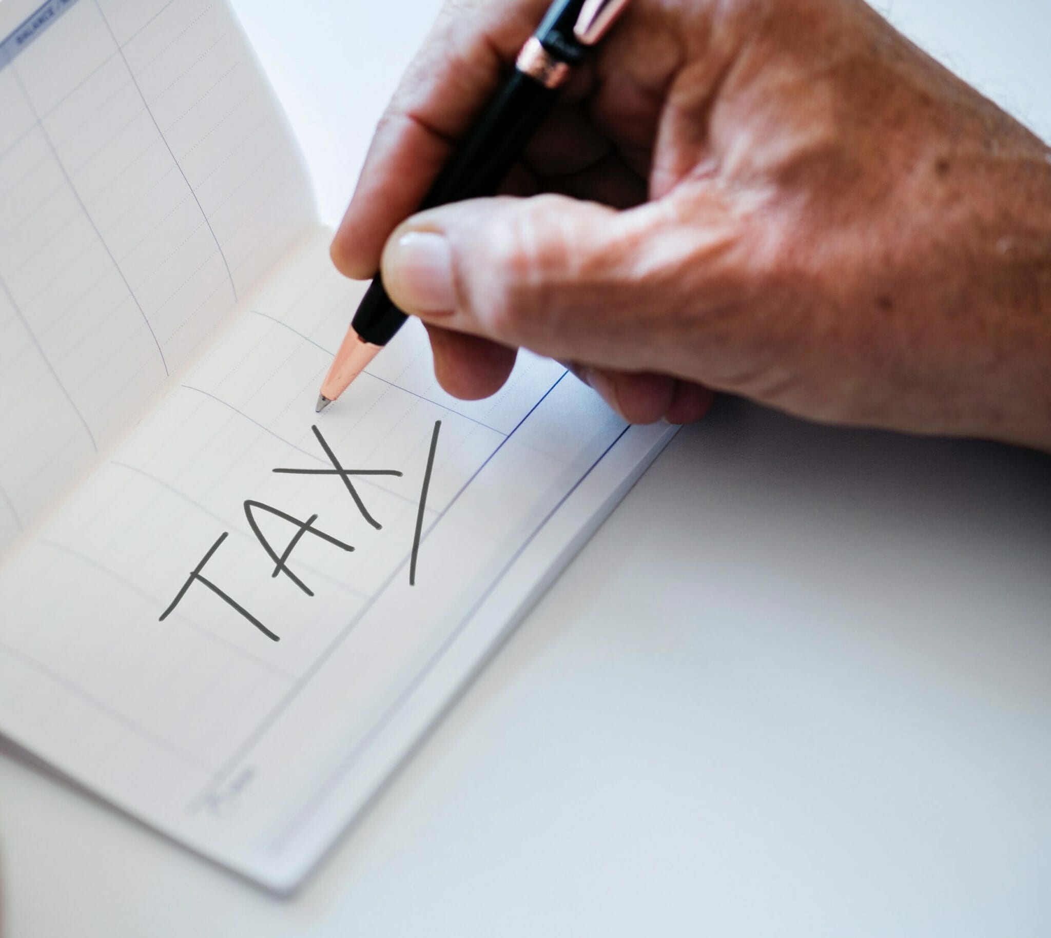 writing the word Tax on paper