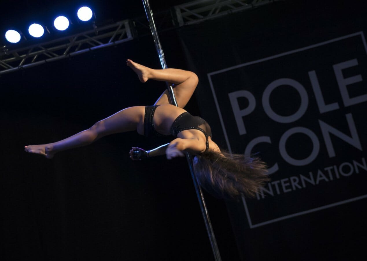 Pole dancer executes an inside leg hang