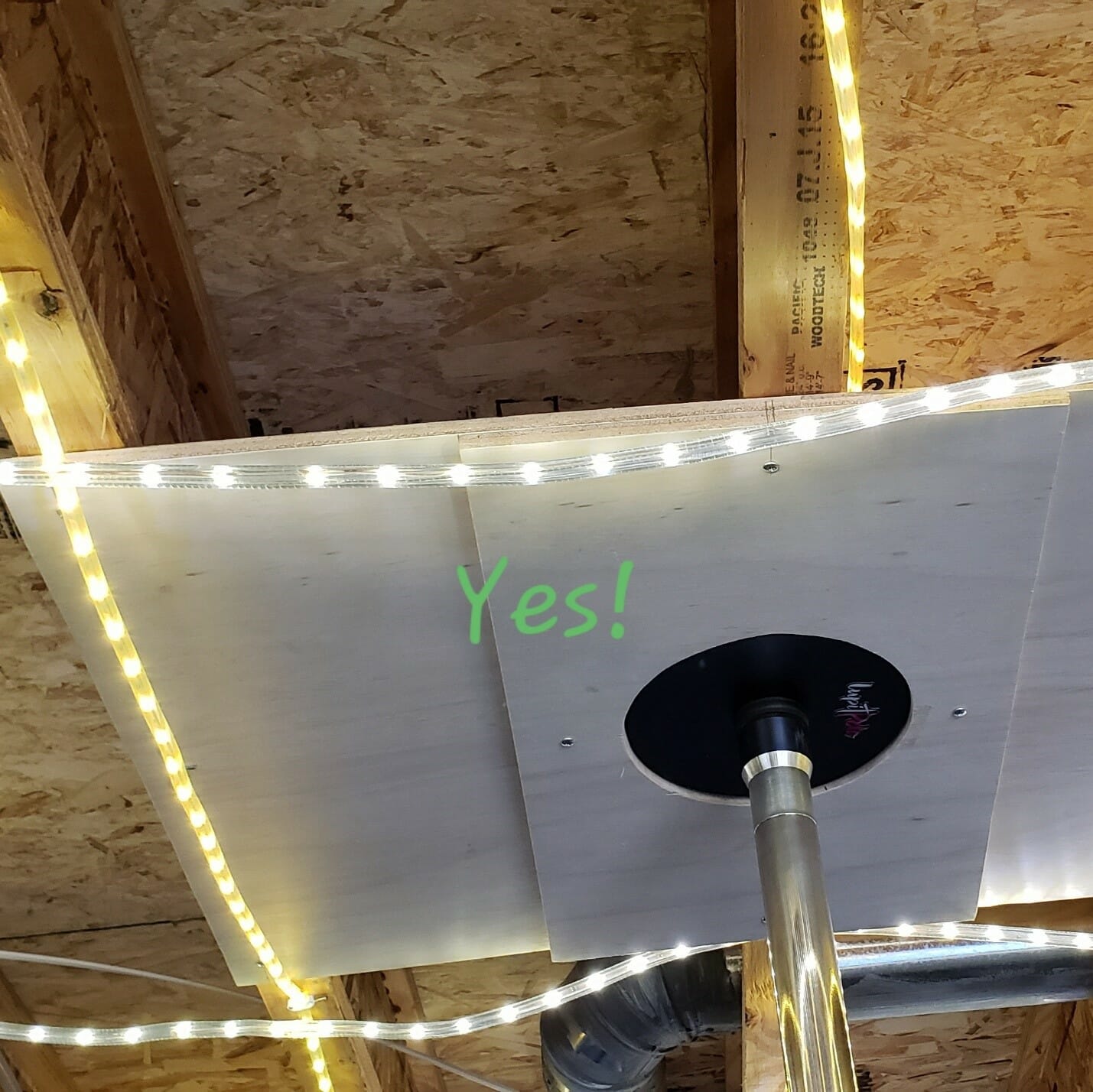 Ceiling picture with a pole on a reinforced plywood sheet outlined by rope lights.