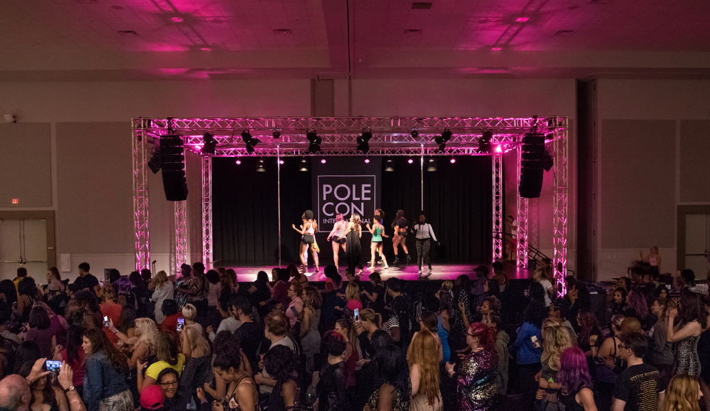 Distance image of a troupe of dancers on the PoleCon stage.