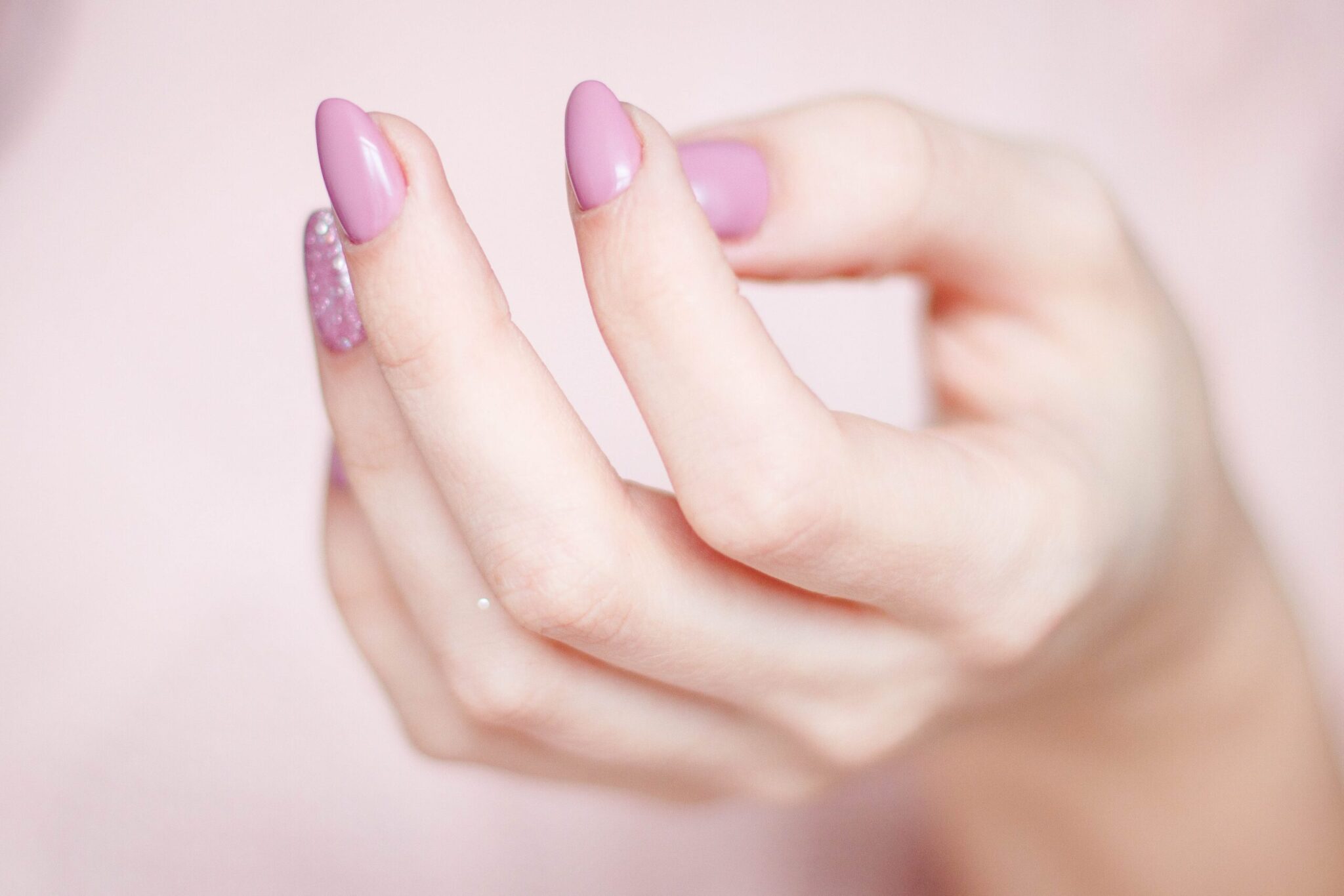 Image of hand with pink / glitter polish