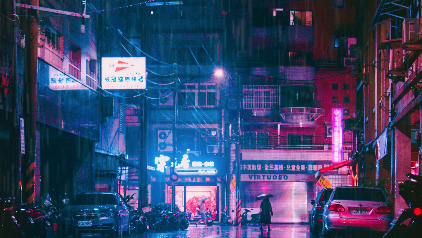 Image of mostly empty street at night lit by neon signs.