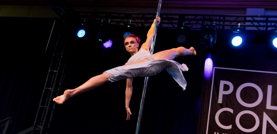 Pole dancer demonstrates a reverse Ayesha on stage.