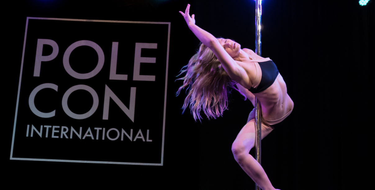 Pole dancer executes a ballerina move on stage.