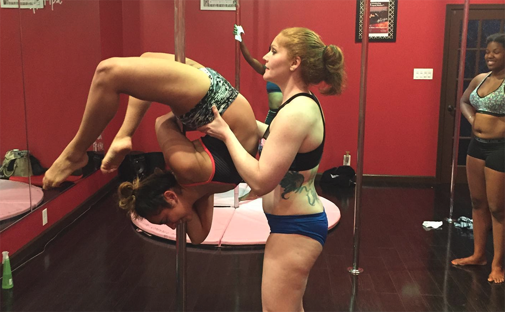 Colleen Jolly spots a student during an advanced inverted pole move.