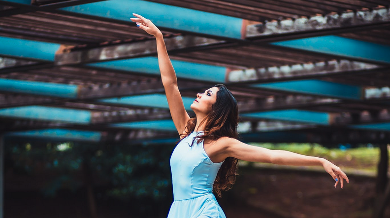 Dancer poses in front of a blurred background.