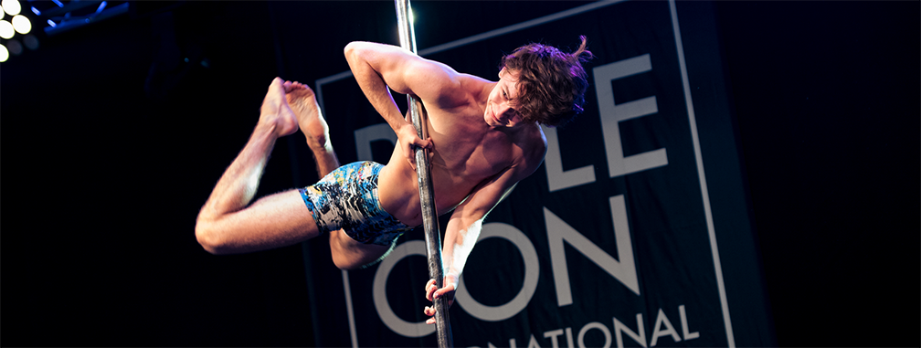 Image of a pole dancer in the middle of a dynamic move.