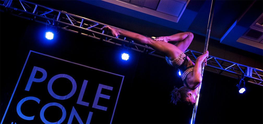 Pole dancer doing an inverted chest-press.