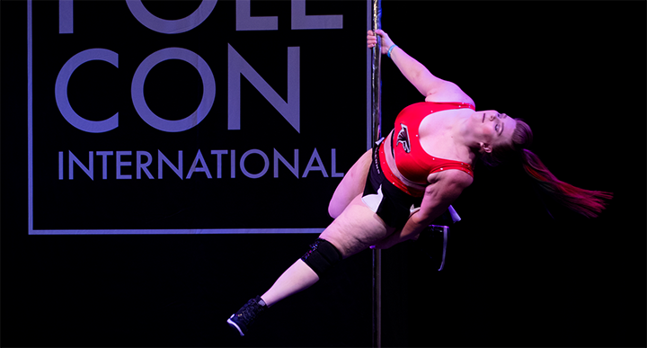 Pole dancer executes a spin on stage.