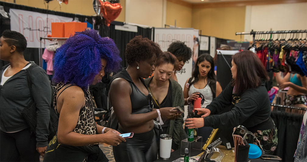 Shoppers compare goods at a vendor's booth at PoleCon.