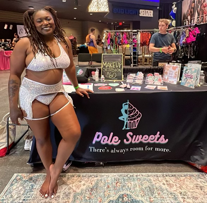 Vendor stands in front of the Pole Sweets booth.