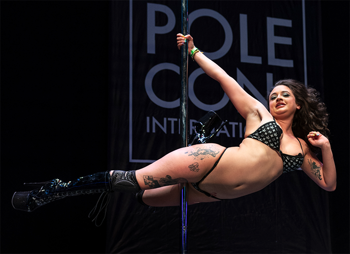 April Haze performs a super man pole move at PoleCon 2023