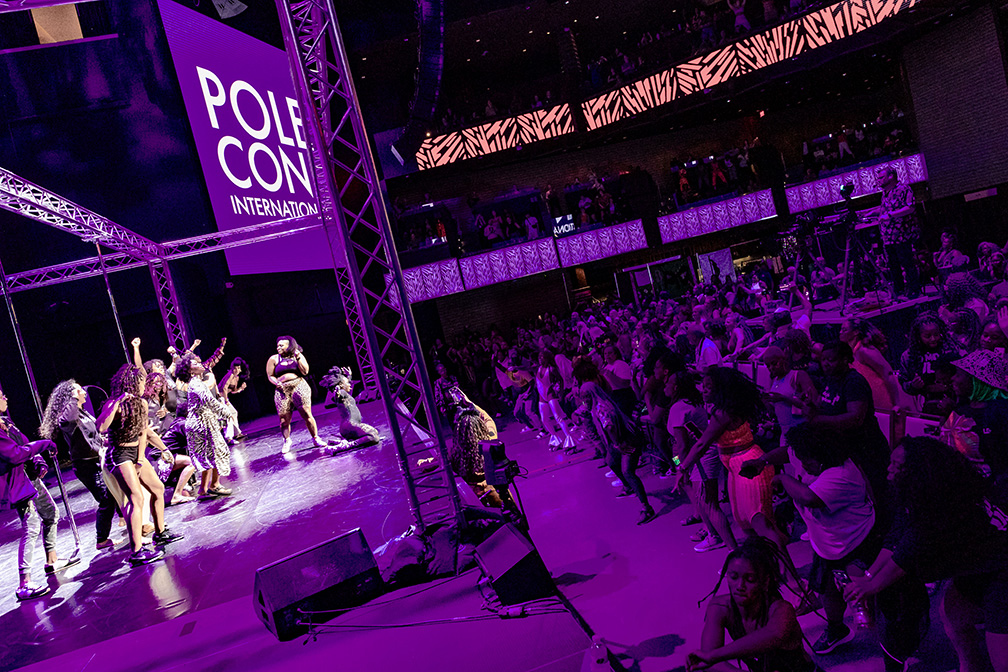 PoleCon 2024 Black Girls Pole Showcase. People on stage dancing and in the audience dancing.