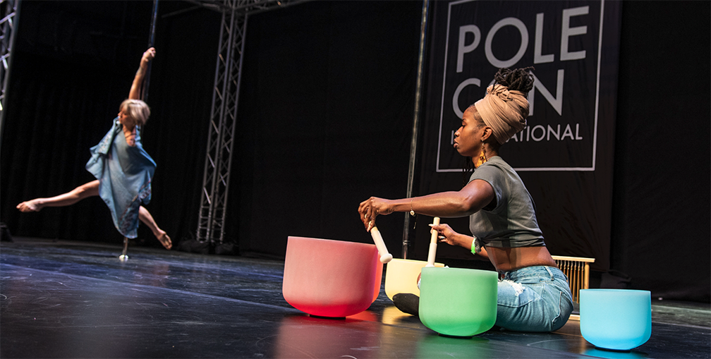 Heidi Coker and Zen Oasis perform with singing bowls at PoleCon 2023.