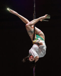Jacki Moon creates a choker shape on the pole 