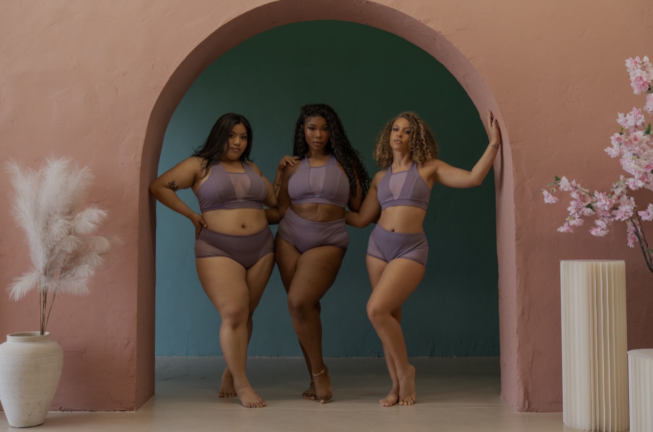 Three women posing in pole wear.